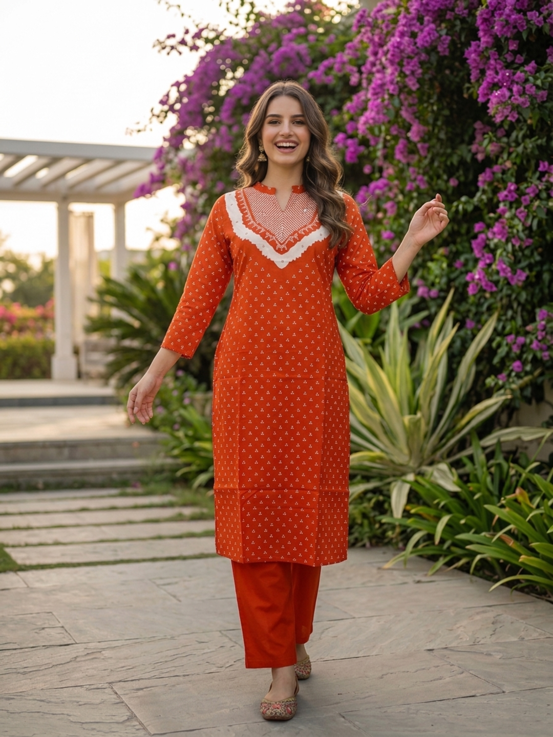 Model wearing rust orange Bandhani print cotton kurta with trousers and dupatta
