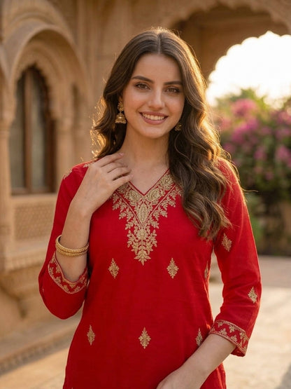 Close-up of ethnic embroidery at the V-neck of the red silk kurta